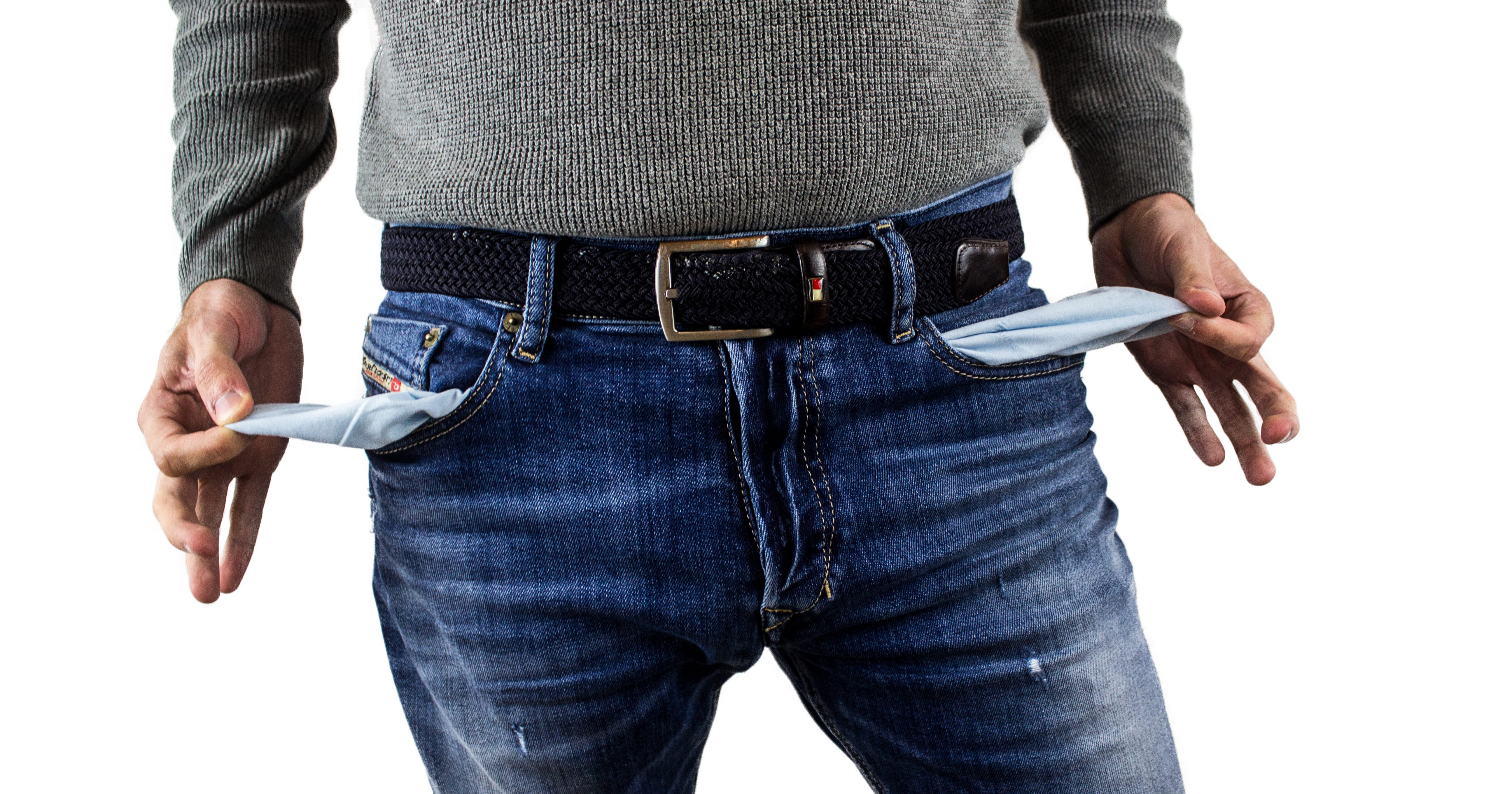 Man wears jeans, turning out pockets to show empty pocket. Make hands  gesture to show no money. Concept, economic crisis. Financial problems.  Broke at the end of month. Lost money. 14880296 Stock