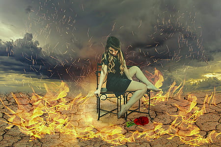 woman sitting on black steel chairs surrounded by fire