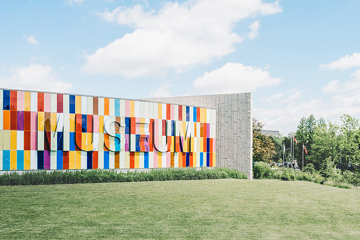 multi-colored Museum outdoor wall surrounded by green grass under blue cloudy sky