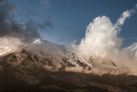 white and grey mountain with white snow and clouds under the blue sky during daytime