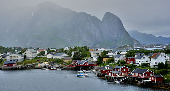 photo of town beside seashore apart from mountain