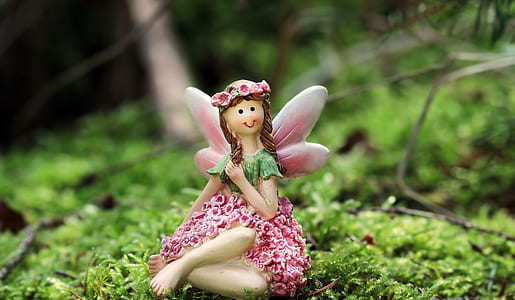 pink and green figure of a fairy on green leaf